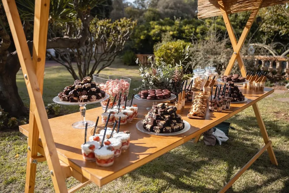 Mesa dulce al aire libre con brownies y vasitos de postre